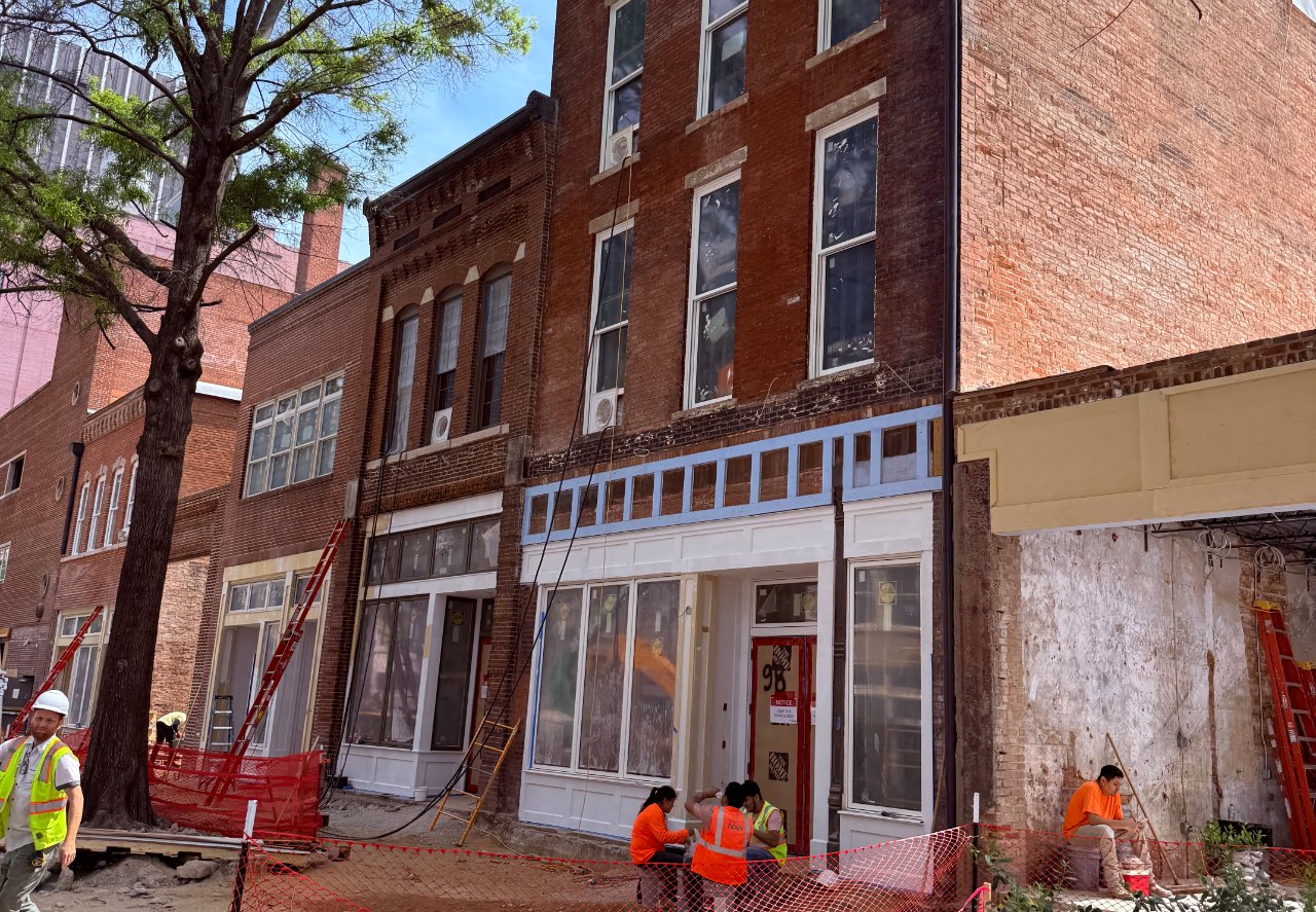 Historic Broad Street storefronts mid-revitalization with work crews in South Downtown Atlanta